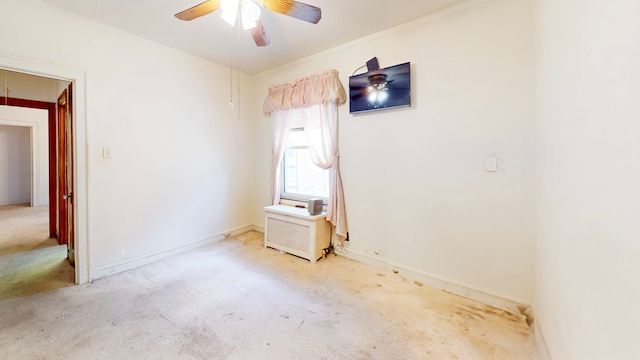 carpeted spare room with ceiling fan and baseboards