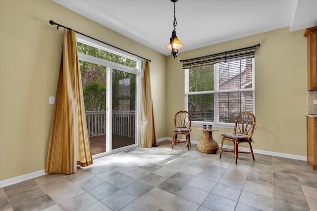 sitting room with baseboards and a healthy amount of sunlight