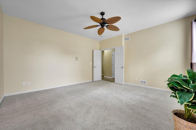 carpeted spare room with a ceiling fan, baseboards, and visible vents