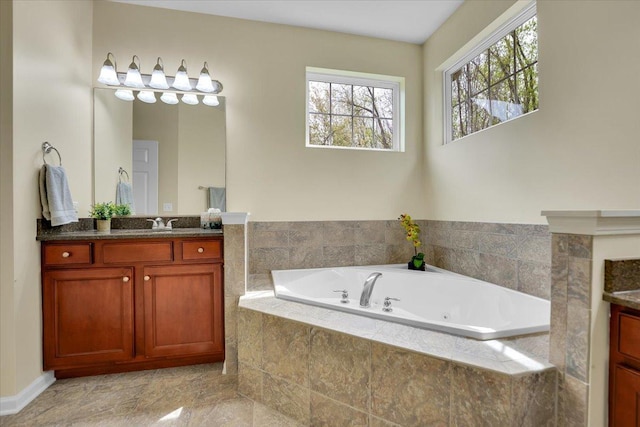 full bath with vanity and a tub with jets