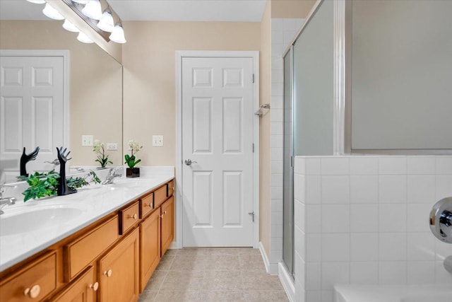 full bath with tile patterned flooring, a sink, and a stall shower