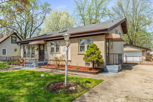ranch-style home featuring an outdoor structure, brick siding, fence, roof with shingles, and a detached garage