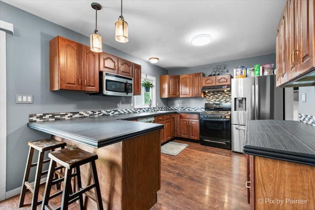 5214 Abbey Dr, Mchenry, IL 60050 - kitchen featuring appliances with stainless steel finishes, dark countertops, a peninsula, and brown cabinets
