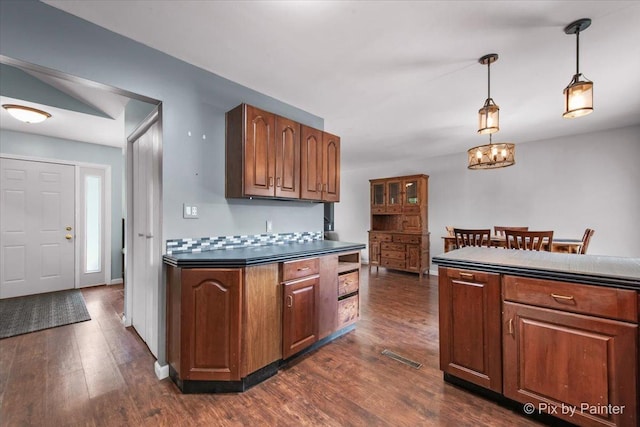 5214 Abbey Dr, Mchenry, IL 60050 - kitchen featuring dark wood-style floors, dark countertops, pendant lighting, a chandelier, and brown cabinetry