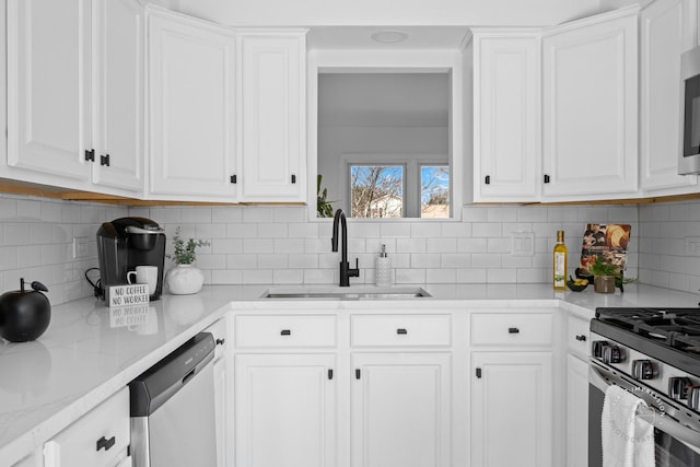 kitchen featuring white cabinetry, stainless steel appliances, and a sink