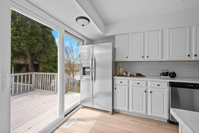 kitchen featuring light wood-style flooring, visible vents, appliances with stainless steel finishes, and decorative backsplash