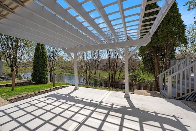 view of patio / terrace with stairway, fence, a water view, and a pergola