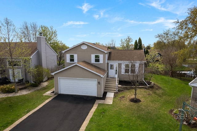 tri-level home with fence, aphalt driveway, and a front yard