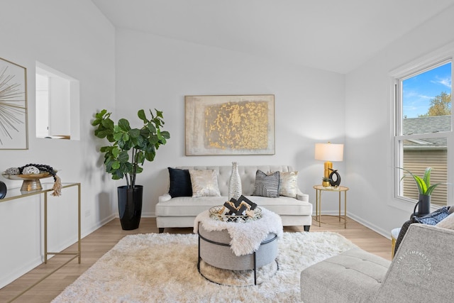 living room featuring vaulted ceiling, wood finished floors, and baseboards