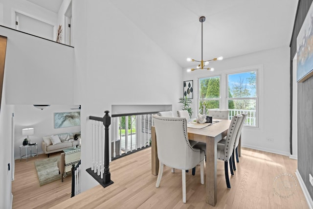 dining space featuring high vaulted ceiling, an inviting chandelier, light wood-style floors, and plenty of natural light