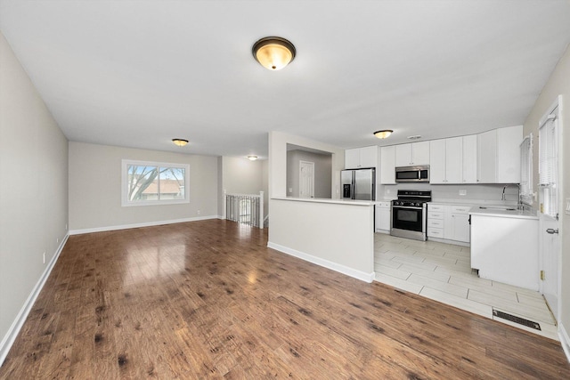 511 Freeman Ave, Streamwood, IL 60107 - kitchen with a sink, stainless steel appliances, open floor plan, light countertops, and light wood-style floors