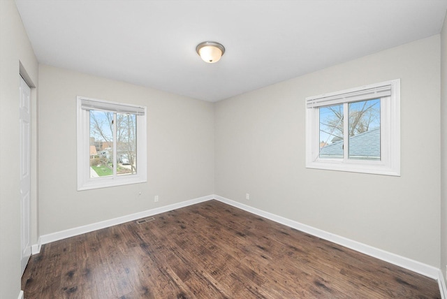 511 Freeman Ave, Streamwood, IL 60107 - unfurnished room with baseboards, dark wood-style floors, and plenty of natural light