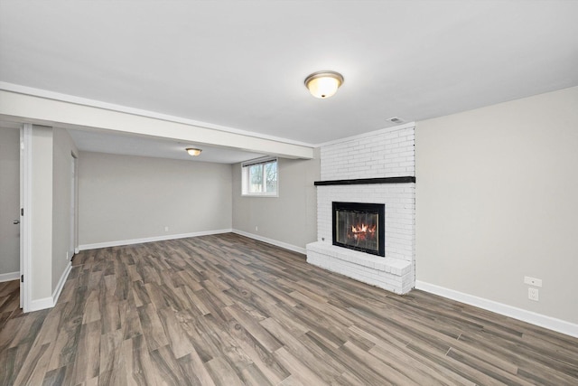 511 Freeman Ave, Streamwood, IL 60107 - unfurnished living room with baseboards, a brick fireplace, visible vents, and wood finished floors