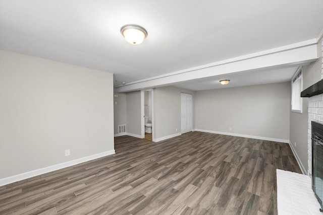 511 Freeman Ave, Streamwood, IL 60107 - unfurnished living room with baseboards, a brick fireplace, visible vents, and wood finished floors