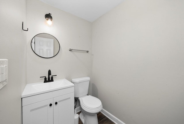 511 Freeman Ave, Streamwood, IL 60107 - half bathroom featuring vanity, toilet, baseboards, and wood finished floors