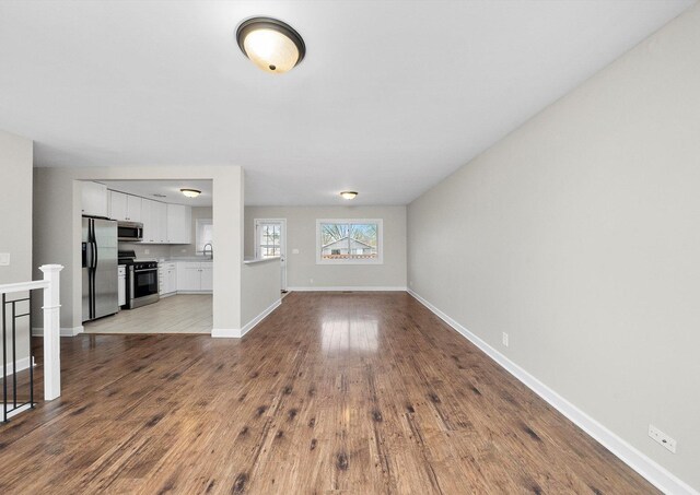 511 Freeman Ave, Streamwood, IL 60107 - unfurnished living room featuring baseboards, dark wood finished floors, and a sink