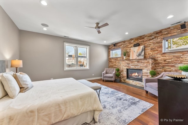 bedroom featuring a fireplace, recessed lighting, wood finished floors, and visible vents