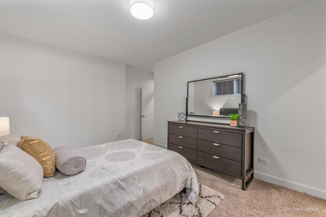 bedroom featuring baseboards and light carpet