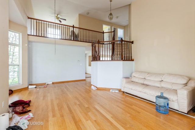 14252 S Hemingway Cir, Plainfield, IL 60544 - unfurnished living room featuring plenty of natural light, ceiling fan, wood finished floors, and a high ceiling