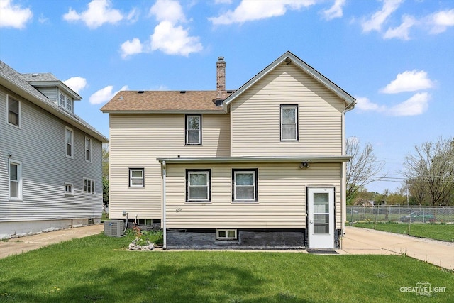 rear view of house with central AC unit and a chimney