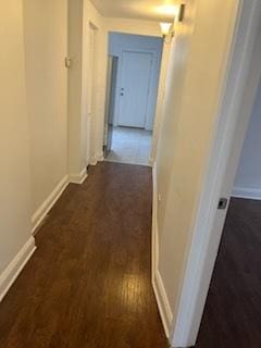 hallway featuring baseboards and wood finished floors