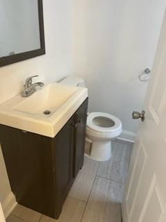 bathroom featuring toilet, tile patterned flooring, and vanity