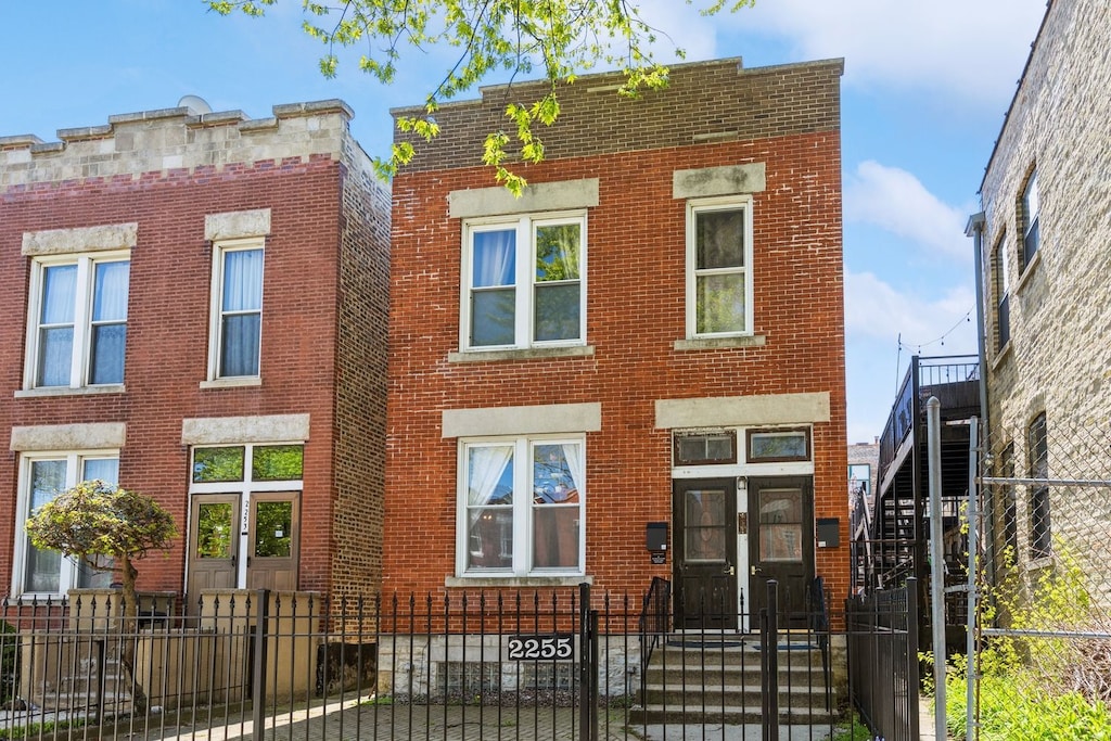 2255 W Erie St, Chicago, IL 60612 - view of front of house featuring a gate, a fenced front yard, and brick siding