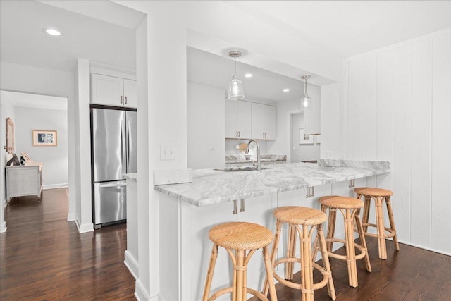 273 Eaton St, Northfield, IL 60093 - kitchen with a breakfast bar area, a sink, freestanding refrigerator, white cabinetry, and dark wood finished floors