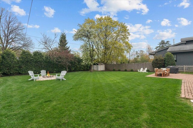 273 Eaton St, Northfield, IL 60093 - view of yard featuring fence, an outdoor structure, a shed, a patio area, and a fire pit