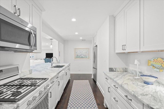 273 Eaton St, Northfield, IL 60093 - kitchen with range with gas stovetop, a sink, white cabinetry, and stainless steel microwave