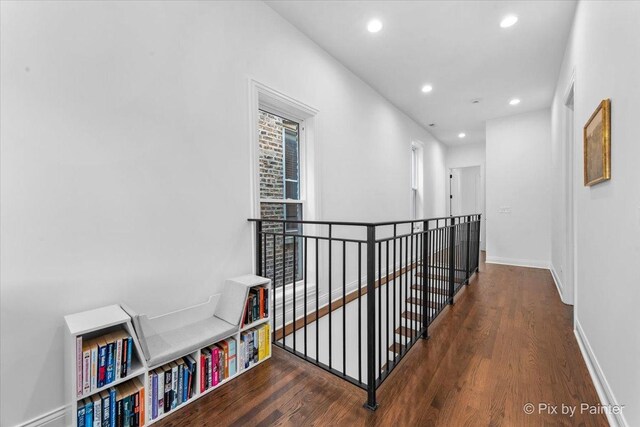 hall featuring recessed lighting, wood finished floors, and an upstairs landing
