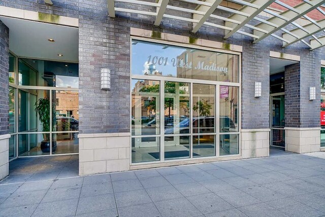 view of exterior entry featuring brick siding