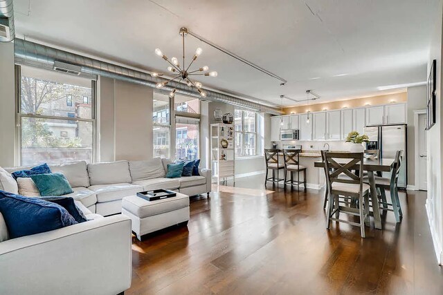living room featuring dark wood-style flooring and a notable chandelier