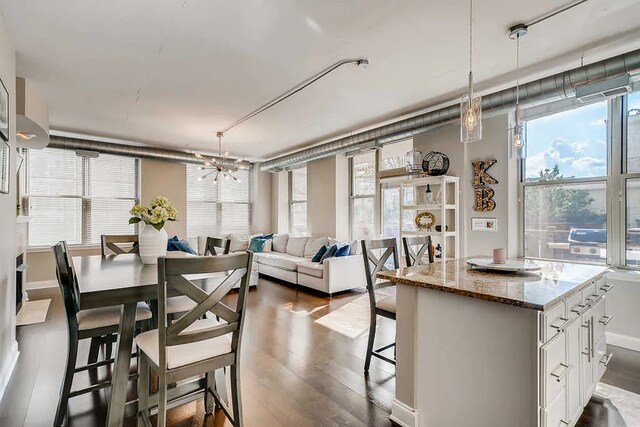 dining area with a chandelier, dark wood-style floors, and a wealth of natural light