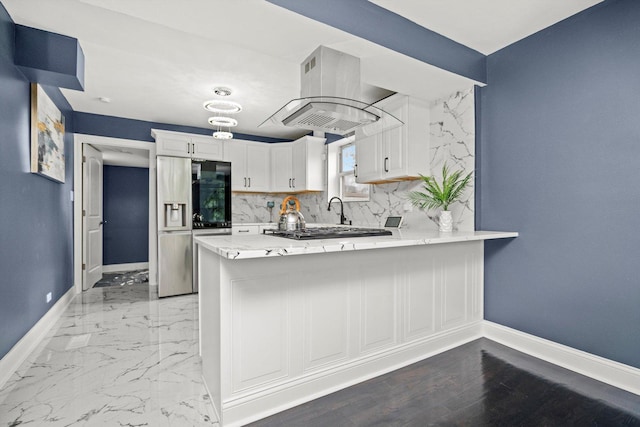 kitchen with stainless steel fridge, a peninsula, baseboards, white cabinetry, and range hood