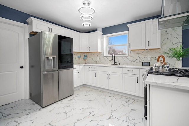 kitchen featuring appliances with stainless steel finishes, tasteful backsplash, a sink, ventilation hood, and marble finish floor