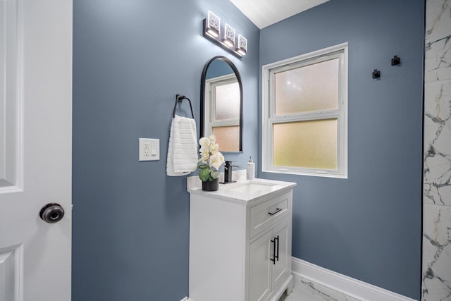 bathroom with vanity, baseboards, and marble finish floor