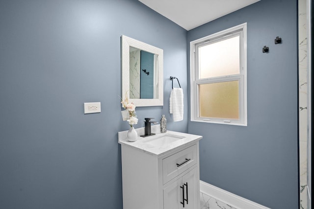 bathroom featuring baseboards, marble finish floor, and vanity