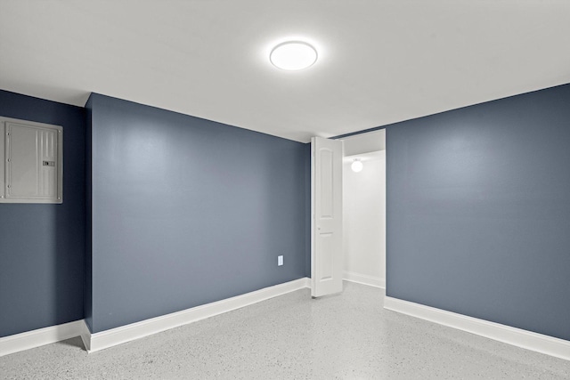 unfurnished room with baseboards and electric panel