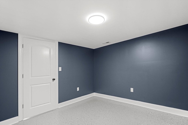 empty room featuring baseboards, speckled floor, and visible vents