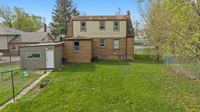 rear view of house featuring a chimney, a lawn, central air condition unit, brick siding, and a fenced backyard
