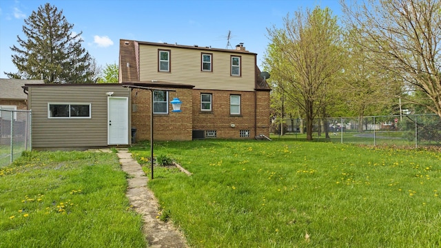 back of house with fence, a chimney, a yard, and brick siding