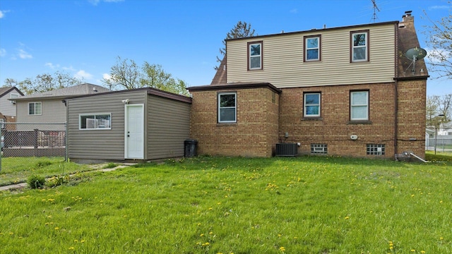 back of property featuring a lawn, fence, a chimney, and brick siding
