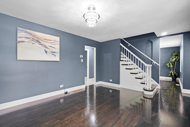 interior space featuring baseboards, stairs, and wood finished floors