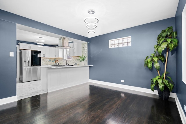 unfurnished living room with baseboards and wood finished floors