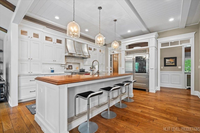 7S361 Arbor Dr, Naperville, IL 60540 - kitchen featuring built in refrigerator, hardwood / wood-style flooring, white cabinets, butcher block countertops, and custom exhaust hood