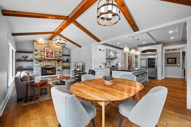 7S361 Arbor Dr, Naperville, IL 60540 - dining space featuring recessed lighting, vaulted ceiling with beams, an inviting chandelier, hardwood / wood-style flooring, and a fireplace