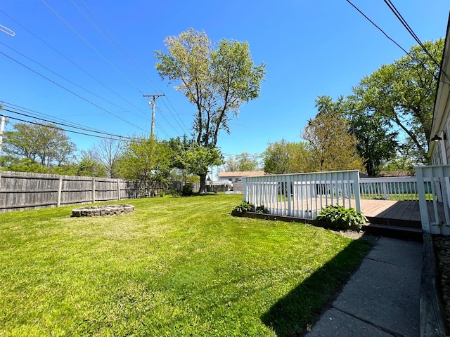 view of yard with an outdoor fire pit and a deck