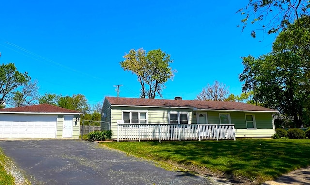 ranch-style house with a detached garage, a front yard, covered porch, and an outbuilding