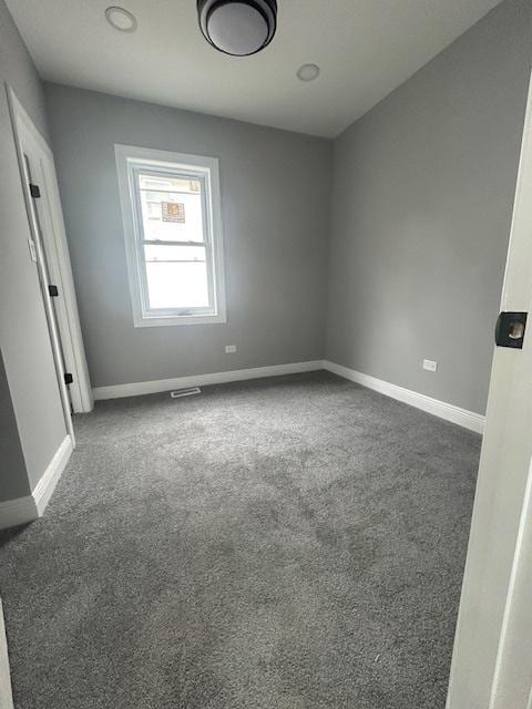 empty room featuring visible vents, carpet flooring, and baseboards